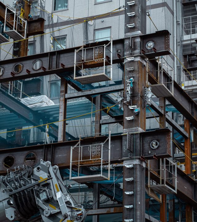 Detailed view of a Japanese construction site showcasing steel beams and modern architecture.